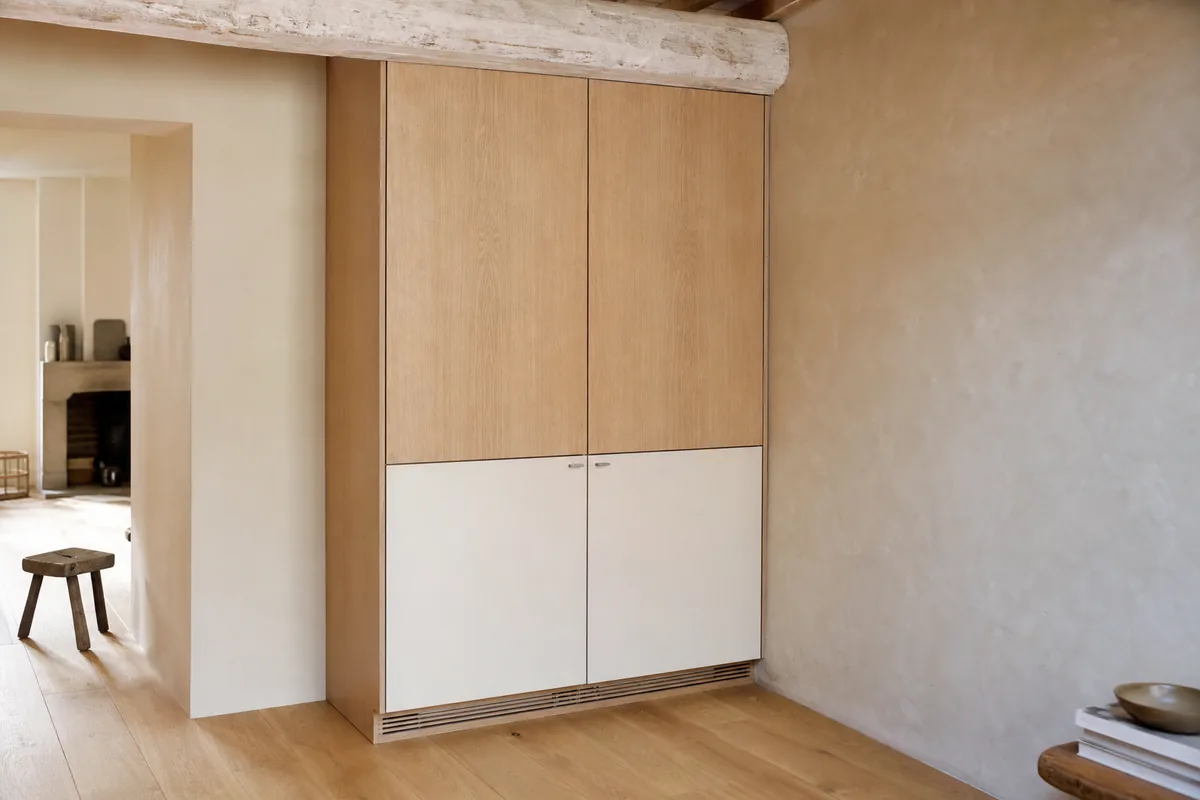 Cuisine en chêne clair installée sous un plafond bas dans une maison de bourg vendéenne
